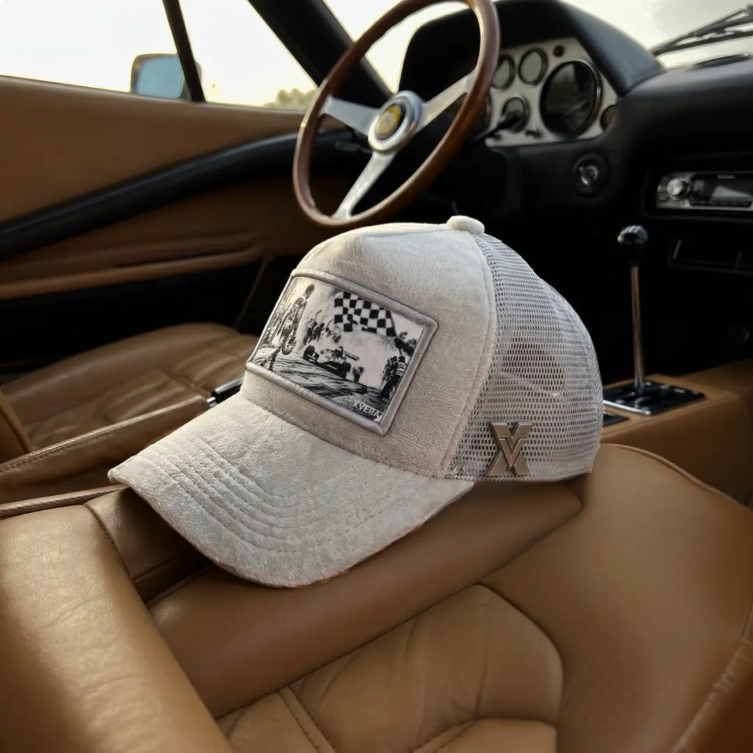 Premium ljus velvet truckerkeps med nät och F1-motiv. Exklusiv keps från XVERA Motor & Racing-kollektion, fotograferad i en vintage bil.
