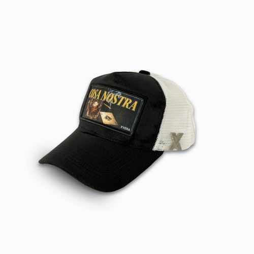 Svart keps i sammet från sidan, som visar den vita nätbaksidan och det kraftfulla COSA NOSTRA trycket. Unisex truckerkeps från XVERA.