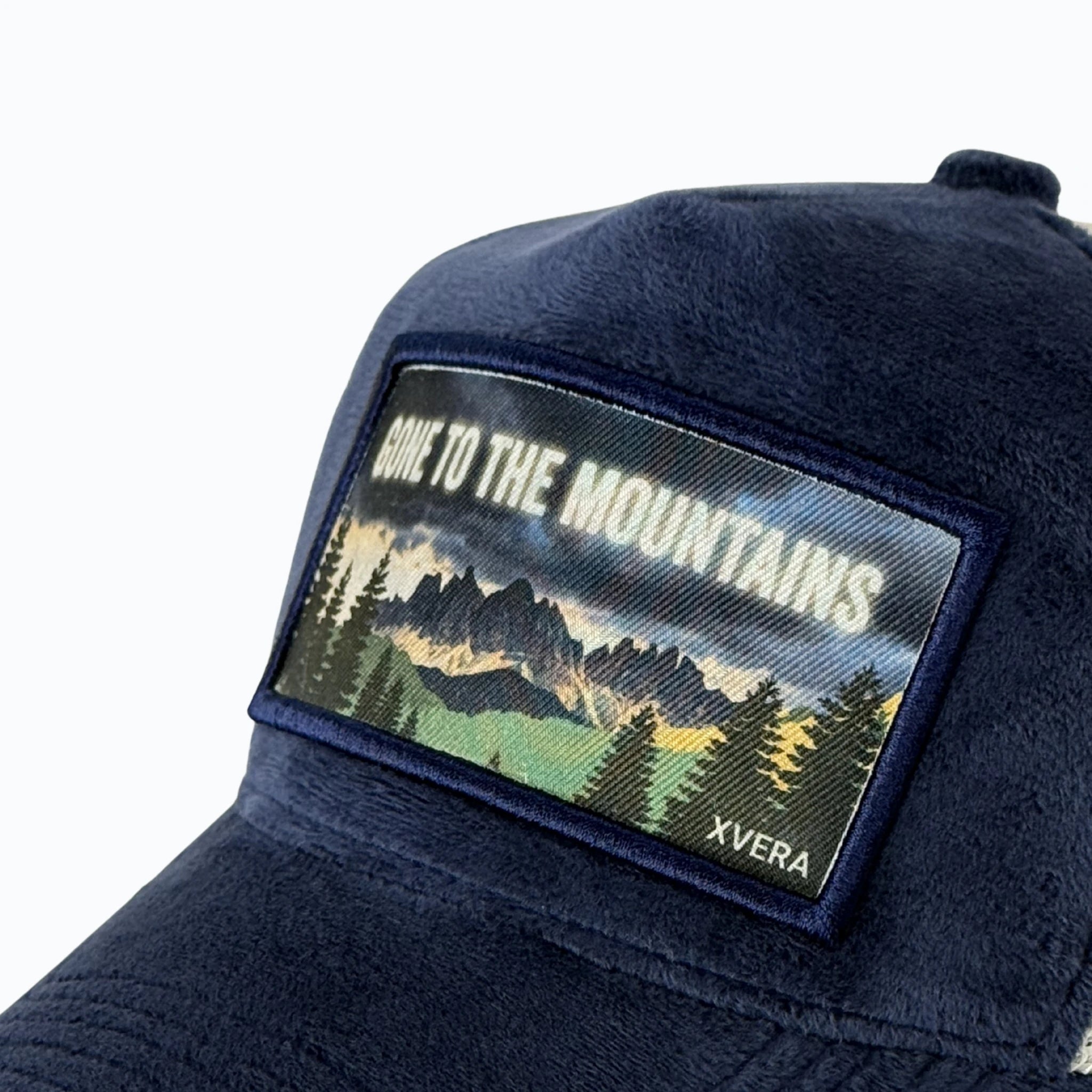 Närbild på det detaljerade landskapstrycket GONE TO THE MOUNTAINS och det exklusiva marinblå sammetsmaterialet från XVERA.