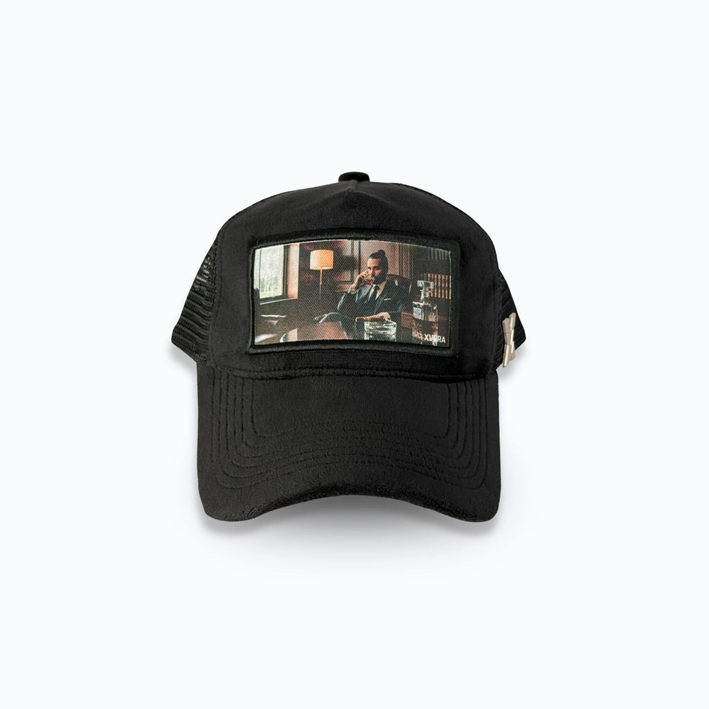 Svart velvet keps framifrån med ett detaljerat tryck av en man i maffia-stil. Exklusiv statement truckerkeps från varumärket XVERA.