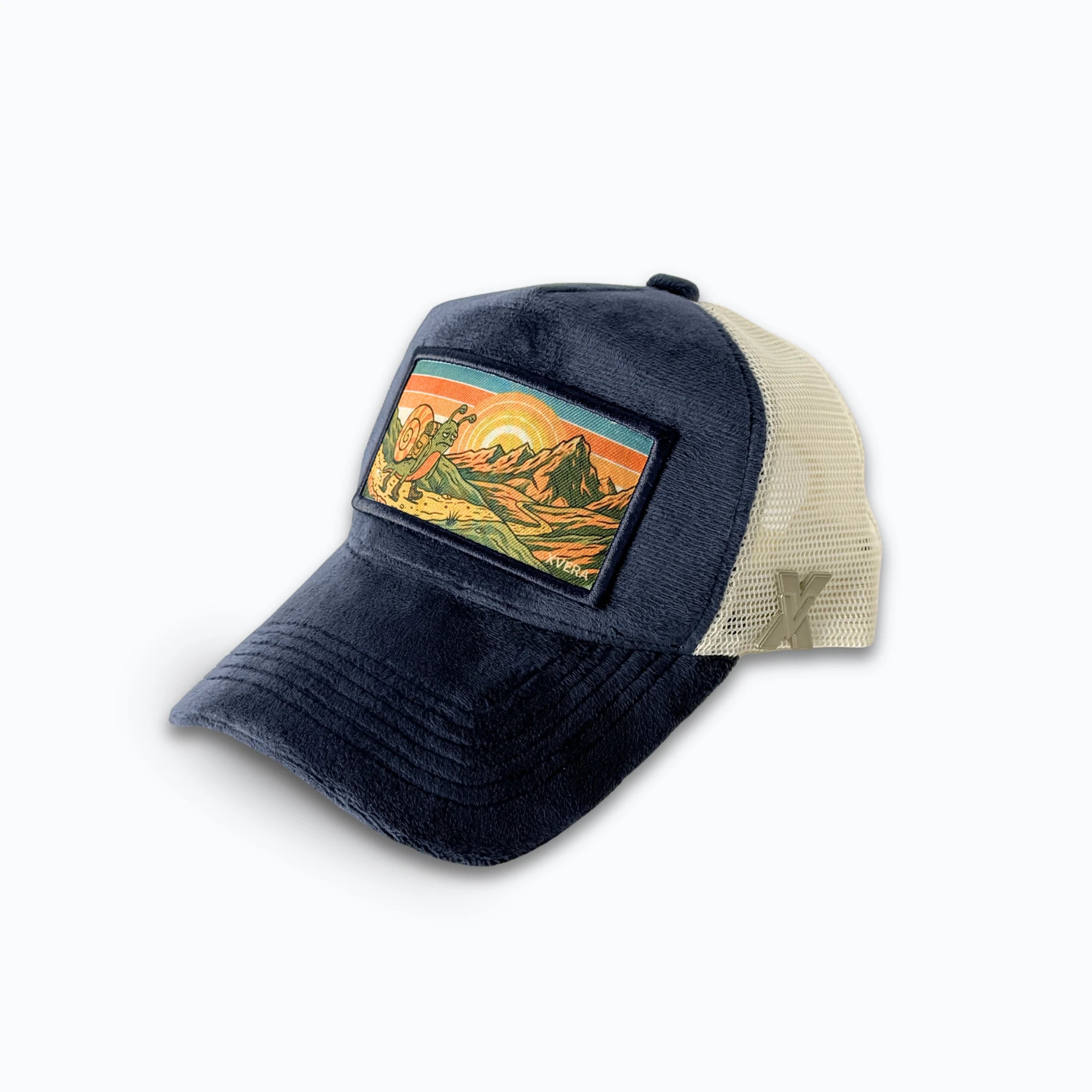 Marinblå keps i sammet från sidan, som visar den cremefärgade nätbaksidan och det unika naturmotivet med en vandrande snigel. Unisex truckerkeps från XVERA.