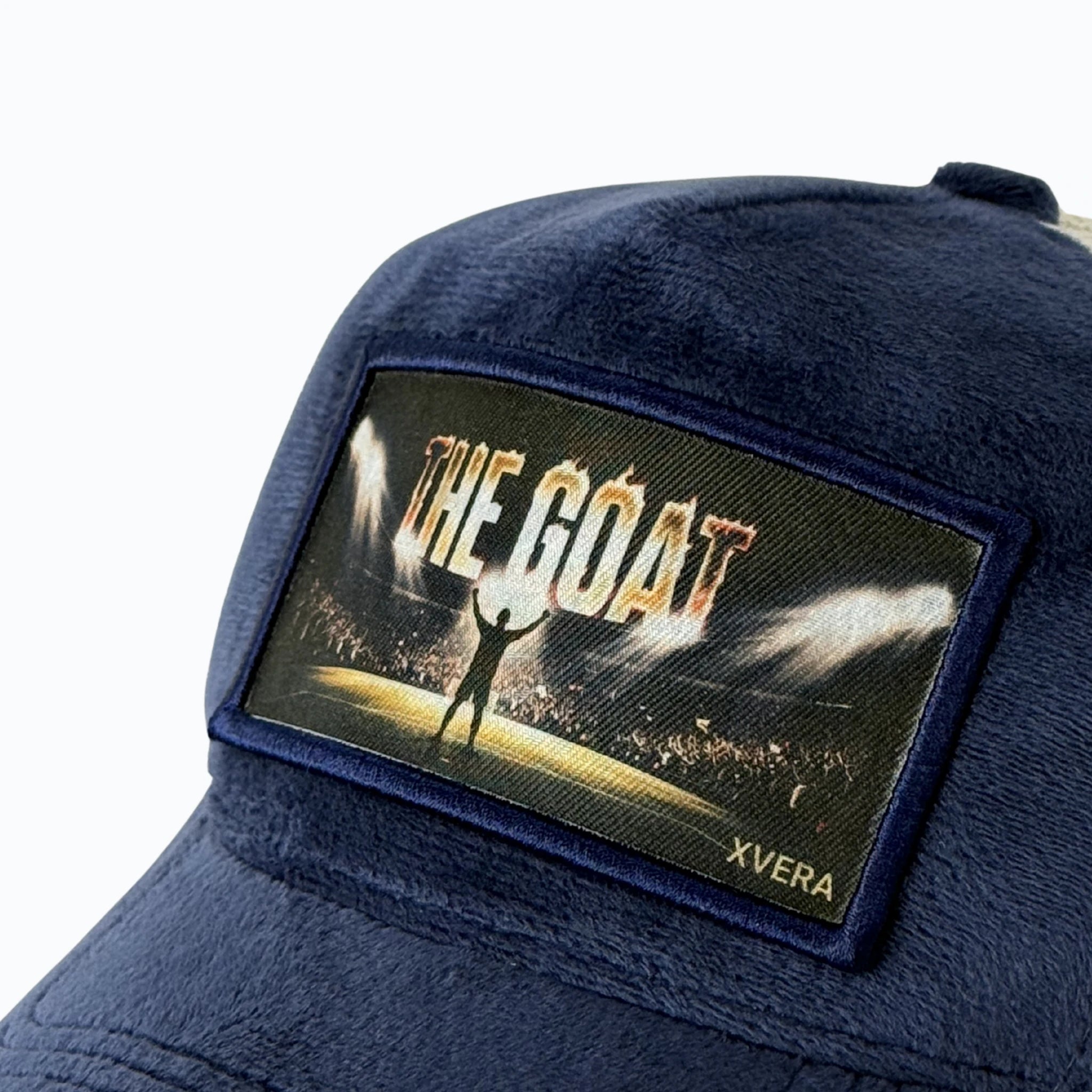 Närbild på det detaljerade trycket THE GOAT med en siluett av en idrottare på en arena och det exklusiva marinblå sammetsmaterialet från XVERA.