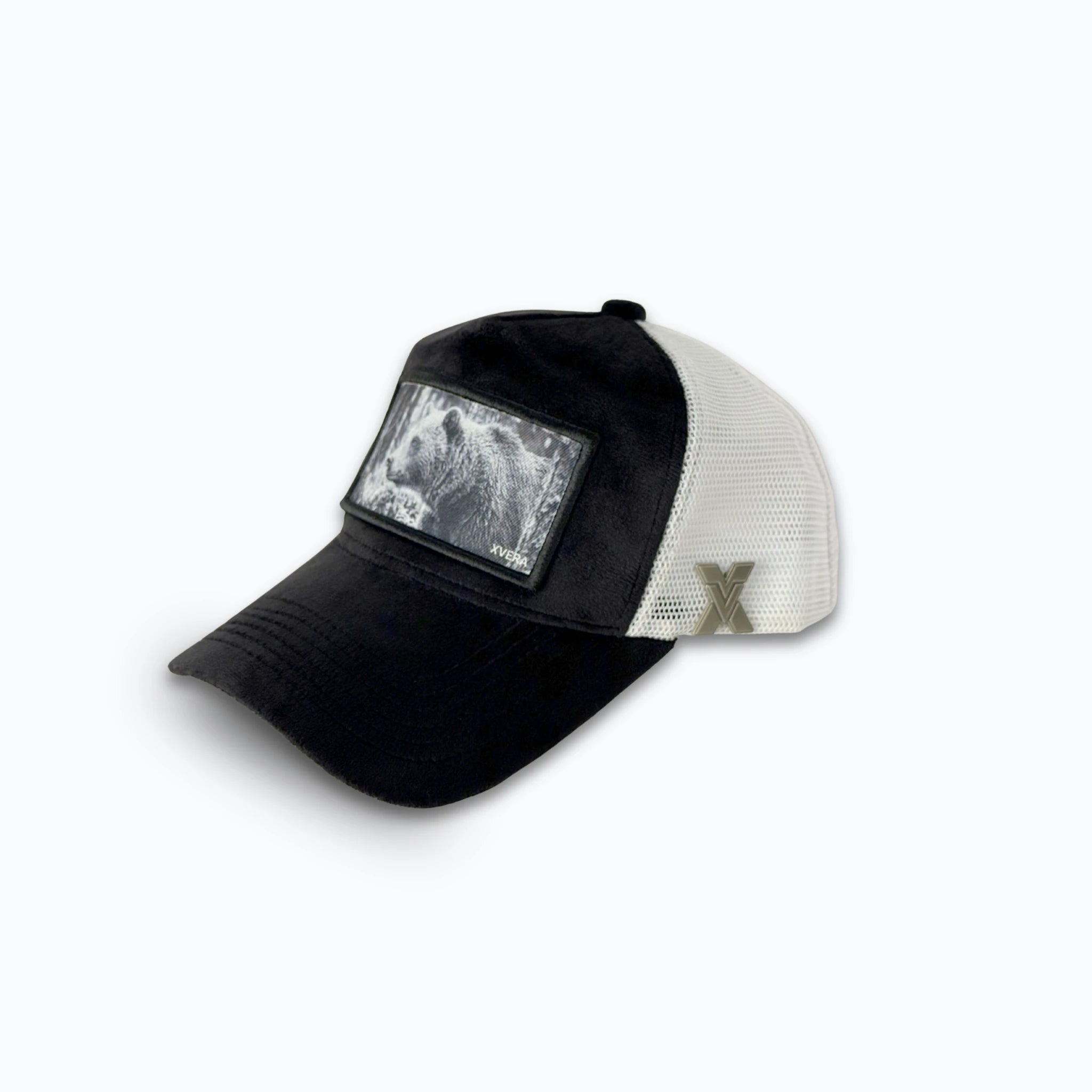 Svart keps i sammet från sidan, som visar den vita nätbaksidan och naturmotivet med en björn. Unisex truckerkeps från XVERA.