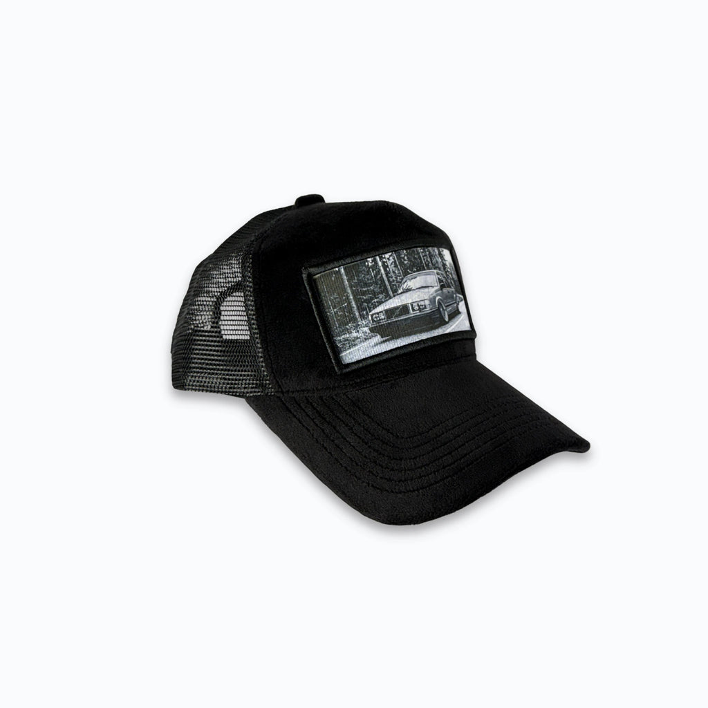 Profilbild av svart velvet truckerkeps med svart nätbaksida och XVERA logotyp i metall. Premium keps med tryck perfekt för svensk motorkultur och raggare.