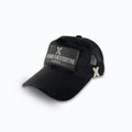 Svart keps i sammet från sidan, som visar passformen, den svarta nätbaksidan med X-logotyp i metall och patchen NOT MADE FOR EVERYONE. Unisex truckerkeps från XVERA.