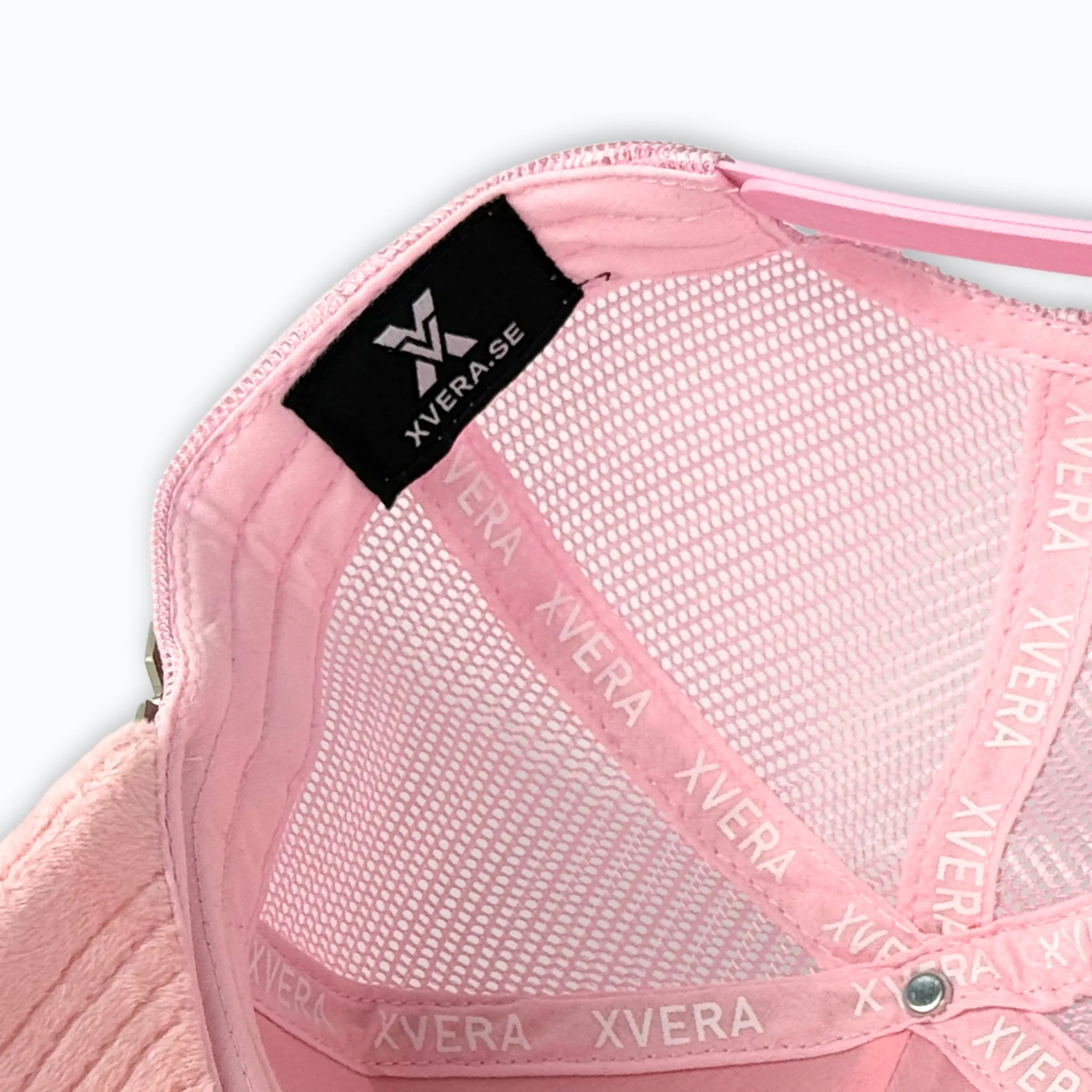 Detaljbild på insidan av en rosa XVERA velvet truckerkeps, som framhäver det exklusiva logobandet och hög kvalitet för optimal passform.